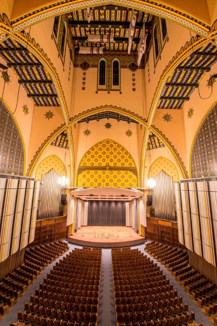 A shot of Irvine Auditorium from the Mezzanine, showing off the main stage, Curtis organ pipes, and beautiful Yellow mural